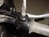 A slot screwdrive is removing the screw holding the cover on the BMW throttle casting.