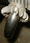 This is an exhaust nut on a BMW motorcycle model R69S.  It shows that some PO (idiot) ruined the original set of holes for removal.  Then a second set were drilled and also ruined.  Some people learn slowly and some never learn.  This could well be the result of using the tool provided in the tool kit. 